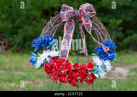 Una corona di fiori blu, bianchi e rossi con nastri a tema bandiera confederata. Questa corona fu posta nel prigioniero Point Lookout del campo di guerra dove 3384 Foto Stock