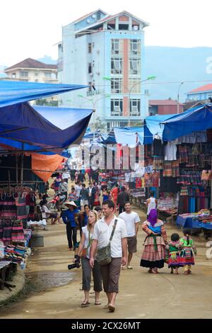 Turisti e locali al mercato Domenica, Bac ha, Vietnam. Hotel Cong fu sullo sfondo Foto Stock