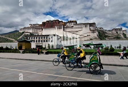 Risciò passando per il Palazzo Potala, Lhasa, Tibet Foto Stock