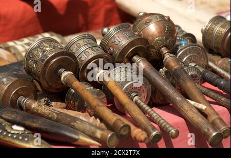 Artigianato nepalese e tibetano ruote di preghiera in vendita su una bancarella di mercato, Kathmandu, Nepal Foto Stock