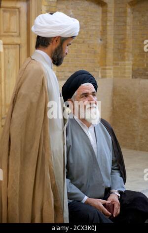 Teologi islamici in conversazione. Mullah a Madrese Khan, Shiraz, Iran Foto Stock