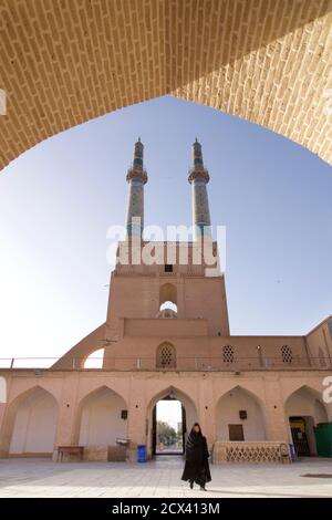 Iraniano donna musulmana in chador nero, a Jameh Masjid. Moschea del Venerdì, Yazd, Iran Foto Stock