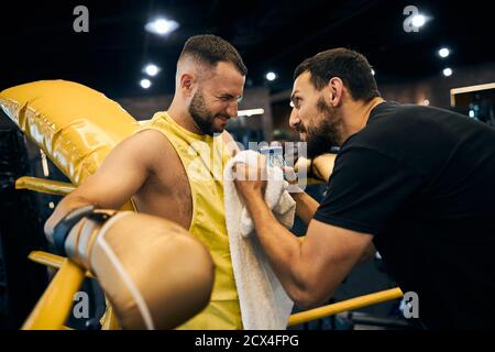 Eccitata allenatrice di boxe che dà istruzioni al suo allievo Foto Stock