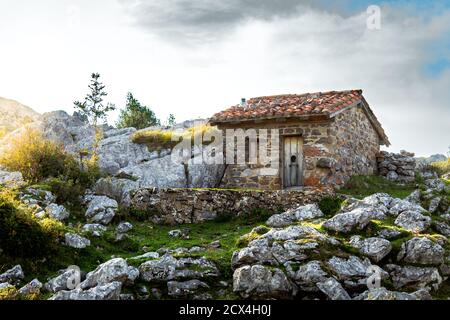 Tramonto in montagna accanto a una vecchia cabina in pietra che serve pastori per trascorrere le notti. Foto Stock