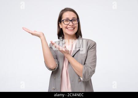 Felice donna d'affari sorridente in occhiali mostrando copyspace. Foto Stock