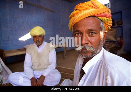 Villaggio headmen in bianco con turbanti distintivo. Villaggio rurale riunione vicino a Jodhpur, Rajasthan, India Foto Stock