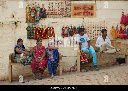 Donne indiane, una con bambino, su una panchina. Jaisalmer, Rajasthan, India Foto Stock