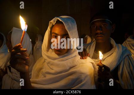 Pellegrini etiopi e adoratori che celebrano Fasika nella chiesa di Bet Medhame Alem. Pasqua, Lalibela, Etiopia UN Kuta è un tessuto fatto a mano molti uomini etiopi usano per coprire la testa e le spalle quando indossano abiti fatti di chiffon, specialmente quando frequentano la chiesa. È costituito da due strati di tessuto Foto Stock