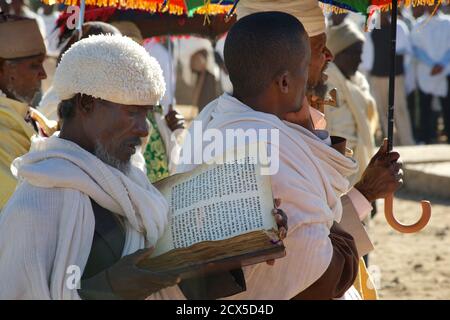 Sacerdoti etiopi che frequentano un funerale nelle loro vesti liturgiche. Lettura dalla bibbia. Axum, Tigray, Etiopia Foto Stock