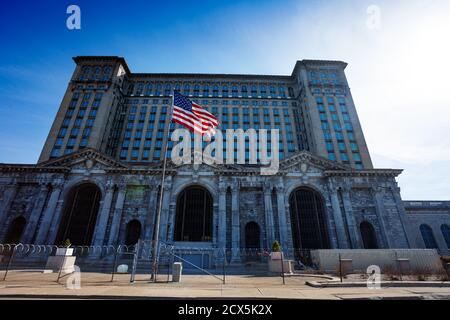 Vista dell'ingresso principale del Michigan Central Train Depot abbandonato con gli Stati Uniti bandiera davanti ad esso Foto Stock