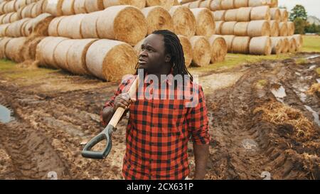 Ritratto di giovane agricoltore africano con forchetta a caraffa sulle spalle. Foto di alta qualità Foto Stock