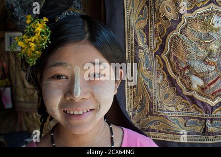 Bambino birmano con la faccia dipinta di thanaka - distintamente birmano. Mandalay. Birmania. 1. Thanaka è una pasta cosmetica bianca-giallastra fatta da corteccia di terra. Si tratta di una caratteristica culturale peculiare e idiosincratica del Myanmar (ex Birmania) visto comunemente applicato al viso e talvolta alle braccia di donne e ragazze e, in misura minore, di uomini e ragazzi Foto Stock