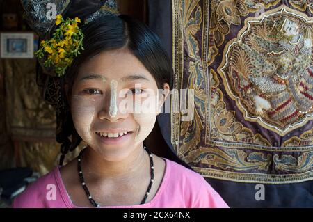 Bambino birmano con la faccia dipinta di thanaka - distintamente birmano. Mandalay. Birmania. 1. Thanaka è una pasta cosmetica bianca-giallastra fatta da corteccia di terra. Si tratta di una caratteristica culturale peculiare e idiosincratica del Myanmar (ex Birmania) visto comunemente applicato al viso e talvolta alle braccia di donne e ragazze e, in misura minore, di uomini e ragazzi Foto Stock