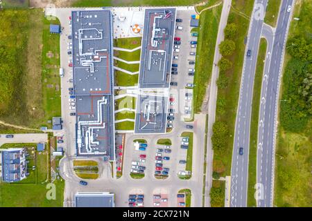 Centro commerciale o centro commerciale e parcheggio per auto. Parcheggio cittadino con auto diverse. Area ad albero. Vista dall'alto della zona di parcheggio con vari veicoli. Vita in città. Foto Stock