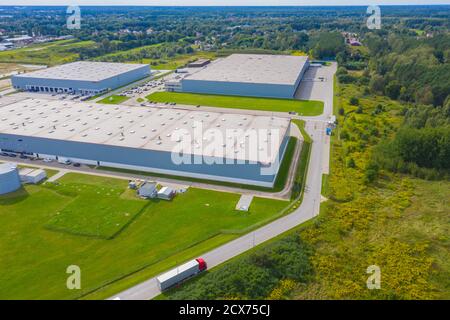 Vista aerea del magazzino con i camion che guidano verso il centro logistico. Contesto industriale. Logistica dall'alto. Foto Stock