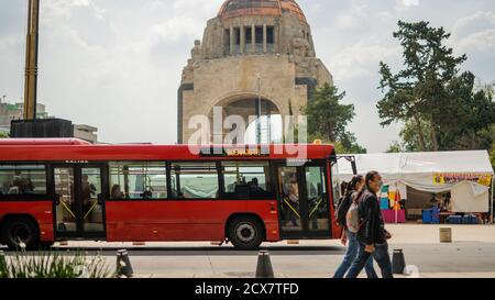Pedoni e un autobus rosso che passa davanti al Monumento Foto Stock