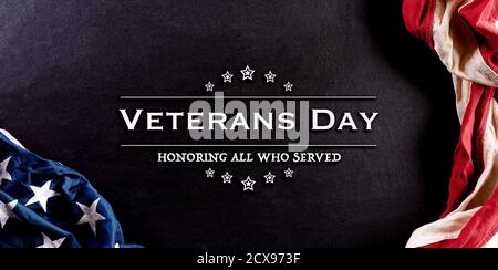 Concetto di Happy Veterans Day. Bandiere americane contro sfondo lavagna. Novembre 11. Giorno. Foto Stock