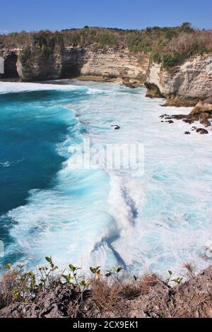 Onde che si infrangono in acque turchesi blu dell'oceano a Nusa Penida, Indonesia Foto Stock