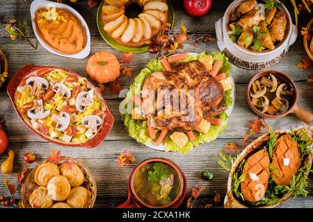Per la festa del Ringraziamento tabella servita con arrosto di tacchino e un sacco di cibo. Foto Stock