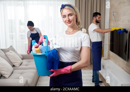 Il personale del servizio di pulizia professionale pulisce il soggiorno in un appartamento moderno Foto Stock