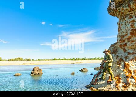 Un pescatore di avventura solista che pesca intorno alle formazioni rocciose di arenaria lungo il fiume Mitchell a Queensland, Australia. Foto Stock