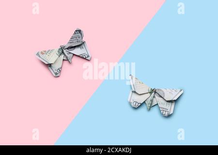 Farfalle Origami fatte di banconote in dollari su sfondo colorato Foto Stock