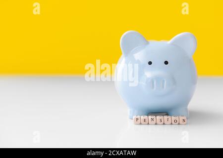 Piggy banca con parola PENSIONE sul tavolo Foto Stock