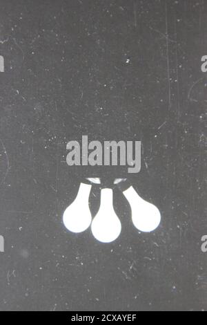 Bella fotografia in bianco e nero d'epoca degli anni '70 di tre lampadine luminose che brillano nell'oscurità. Foto Stock
