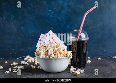 Ciotola di gustosi popcorn con biglietti per il cinema e colazione sfondo scuro Foto Stock