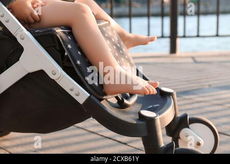 Carino bambino in passeggino all'aperto Foto Stock