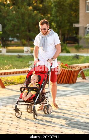 L'uomo e il suo bambino carino in passeggino all'aperto Foto Stock