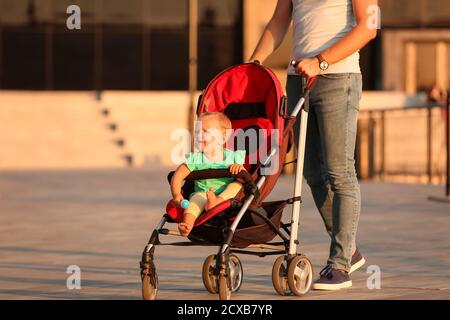 L'uomo e il suo bambino carino in passeggino all'aperto Foto Stock