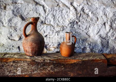 Varie vecchie caraffe, piatti di enologo su una mensola in legno nella cantina Foto Stock