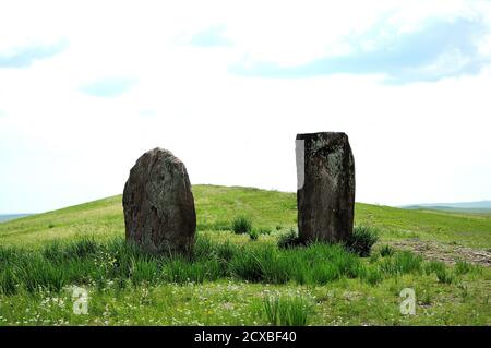 Due antichi Menhir con nastri legati si levano come guardie nella steppa infinita. Porte alla Valle dei Re, Salbyk Steppe, Khakassia, Siber del Sud Foto Stock