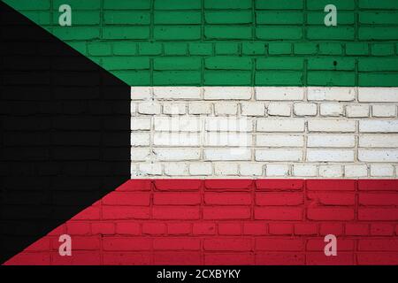 Bandiera nazionale del Kuwait raffigurante in colori pittorici su un vecchio muro di mattoni. Bandiera banner su sfondo muro di mattoni. Foto Stock