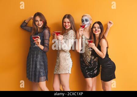 Amici in costumi di Halloween su sfondo a colori Foto Stock