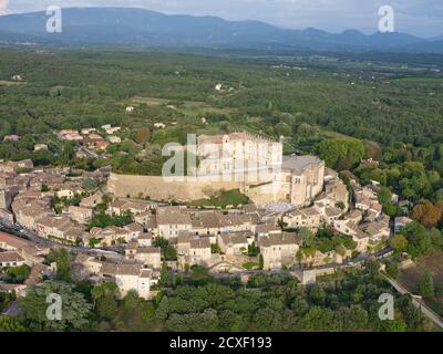 VISTA AEREA. Castello medievale costruito su una collina rocciosa, che domina il borgo antico. Castello di Grignan, Drome, Auvergne-Rhône-Alpes, Francia. Foto Stock