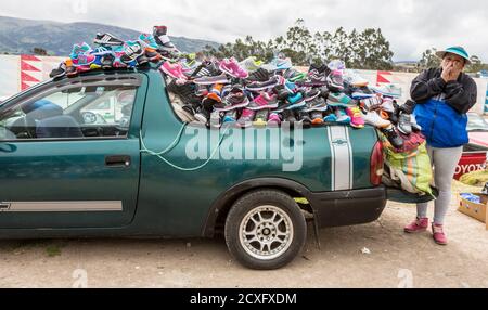 Canar, Ecuador - Luglio 12, 2015 - Una donna vende scarpe fuori dal retro della sua auto presso il mercato del sabato Foto Stock