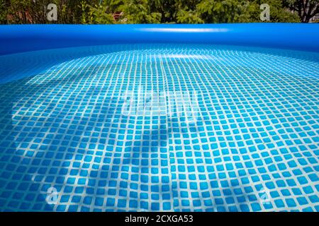 Parte di una piscina gonfiabile blu nel cortile di una casa privata. Foto Stock