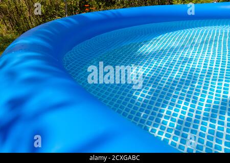 Parte di una piscina gonfiabile blu nel cortile di una casa privata. Foto Stock