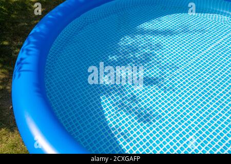 Parte di una piscina gonfiabile blu nel cortile di una casa privata. Foto Stock