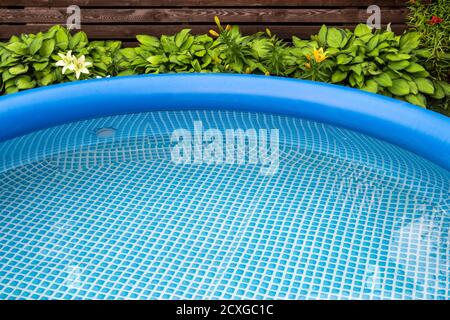 Parte di una piscina gonfiabile blu nel cortile di una casa privata. Foto Stock