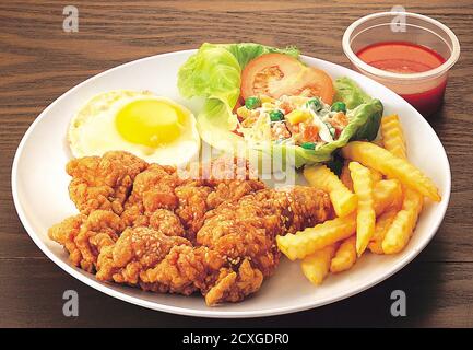 Pollo fritto croccante con patatine fritte, uova fritte e insalata Foto Stock