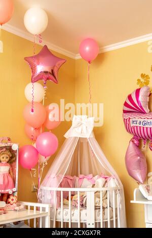 Il letto della bambina nell'angolo della camera è decorato con palloncini. Foto Stock