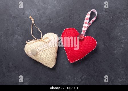 Cuori tessili decorativi su fondo di pietra. Il concetto di San Valentino. Spazio di copia per il testo - immagine Foto Stock