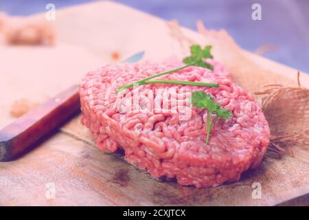 Hamburger rosso di carne primo piano su sfondo nero Foto Stock