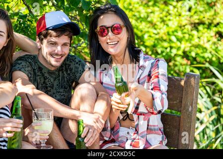 I giovani amici gustano un drink a bordo piscina Foto Stock