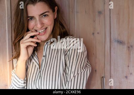 Bella giovane donna sorridente in piedi in casa Foto Stock