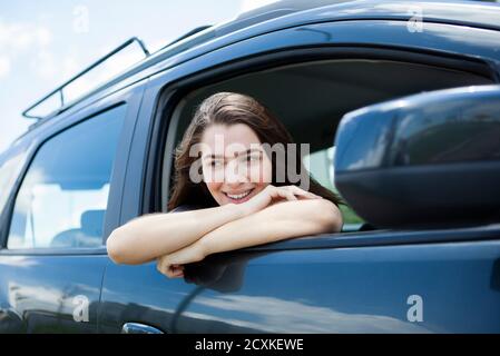 Bella giovane donna sorridente seduto in macchina Foto Stock