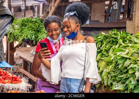 cliente in un mercato che mostra un commerciante qualcosa di eccitante su il suo telefono Foto Stock